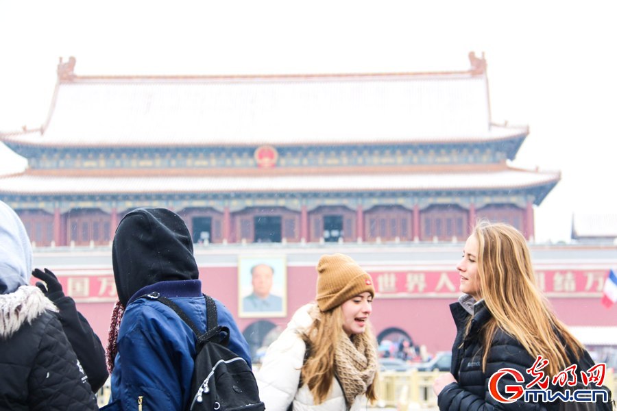 北京城迎来新春第一场雪 外国游客雪中拍照