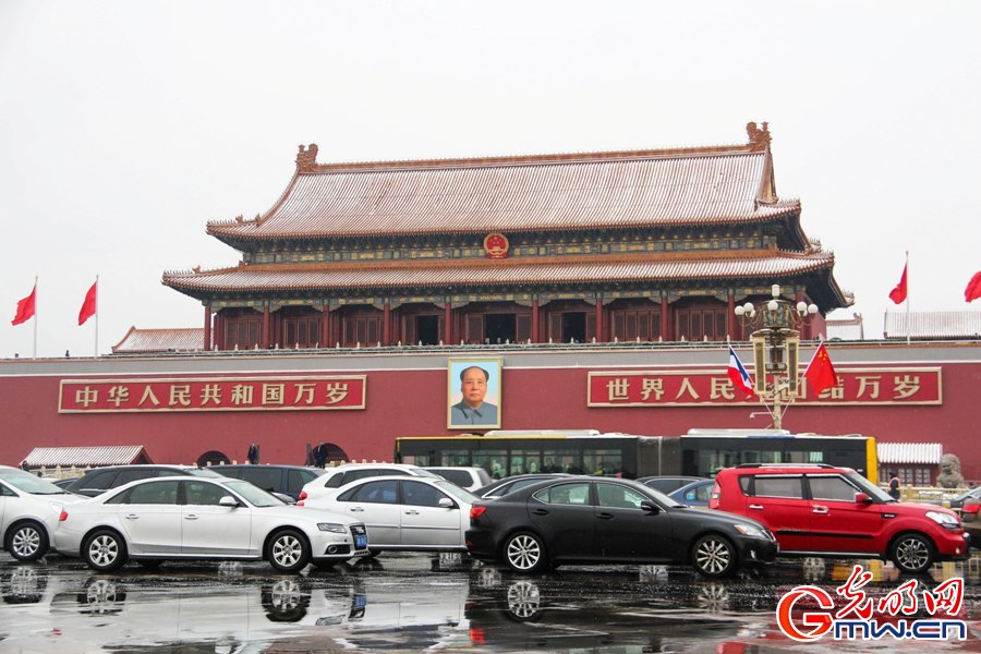 北京城迎来新春第一场雪 外国游客雪中拍照