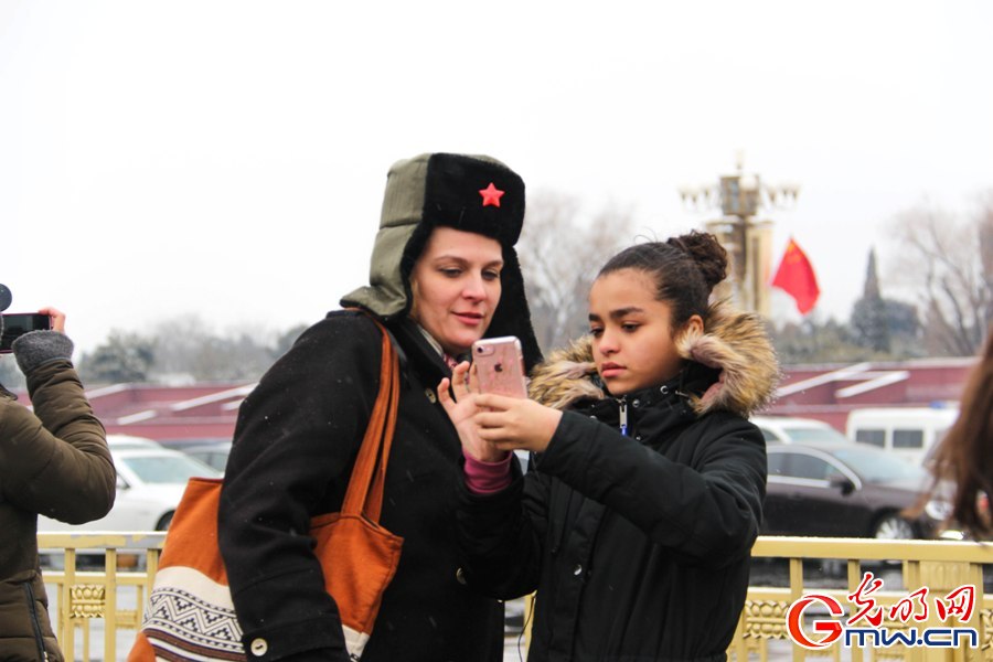 北京城迎来新春第一场雪 外国游客雪中拍照