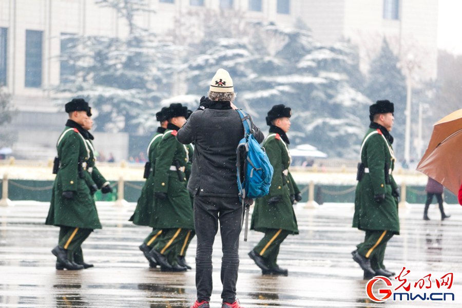 北京城迎来新春第一场雪 外国游客雪中拍照