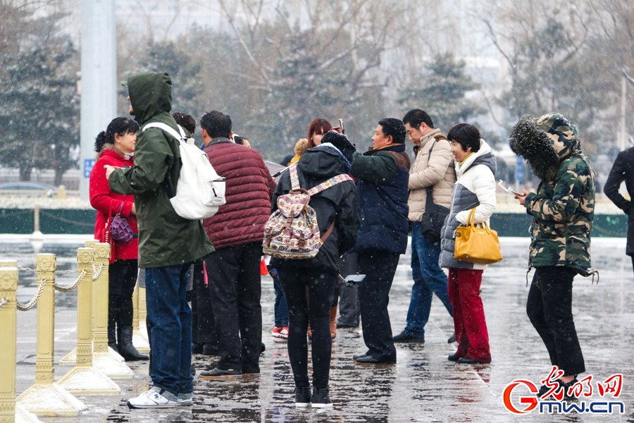 北京城迎来新春第一场雪 外国游客雪中拍照
